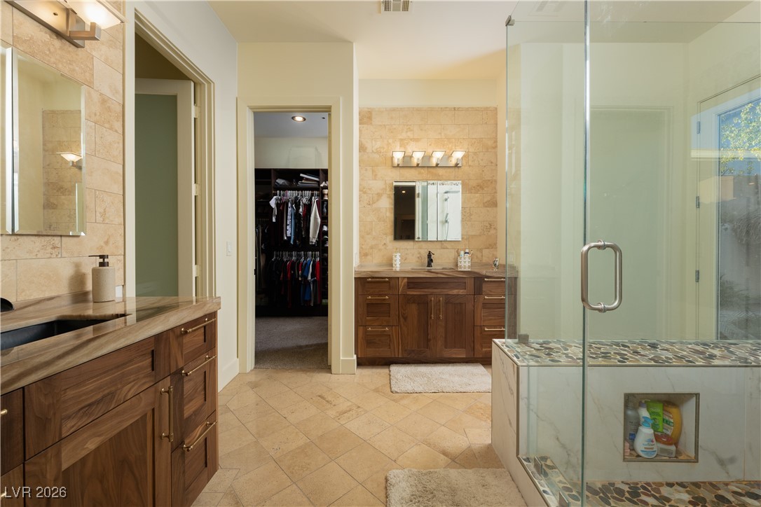 2817 High View Drive Henderson, NV 89014 - Photo 42 of 77 Full bathroom with two vanities, a walk in closet, and a shower stall