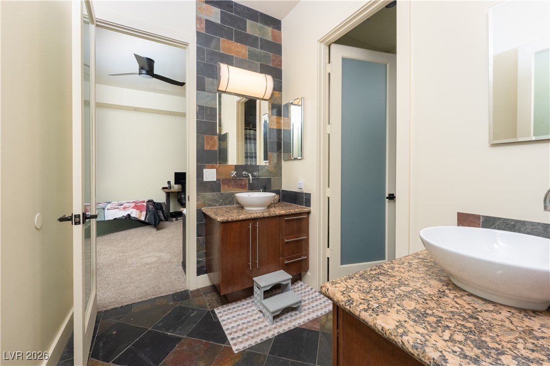 2817 High View Drive Henderson, NV 89014 - Photo 69 of 77 Full bath with stone tile flooring, two vanities, and a ceiling fan