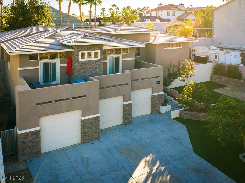 2817 High View Drive Henderson, NV 89014 - Photo 8 of 77 View of front of home with stone siding, stucco siding, driveway, a garage, and a residential view