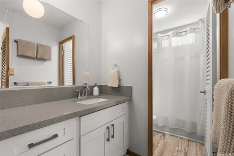 a bathroom with a granite countertop sink and a mirror
