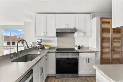 a kitchen with granite countertop a sink stove and cabinets