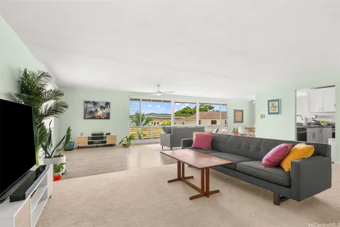 a living room with furniture a flat screen tv and a fireplace