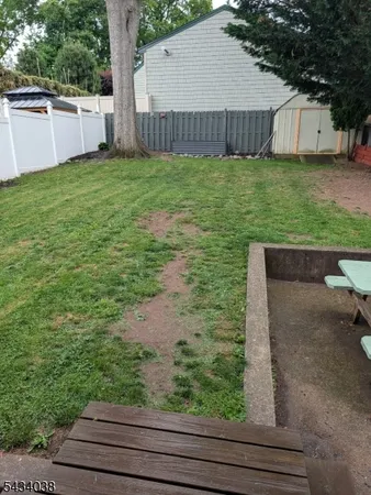 a view of a backyard with barn and large tree