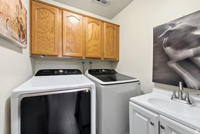 7930 Mustang Loop Road Park City, UT 84098 - Photo 16 of 23 Laundry room featuring cabinet space, washer and dryer, and a textured ceiling