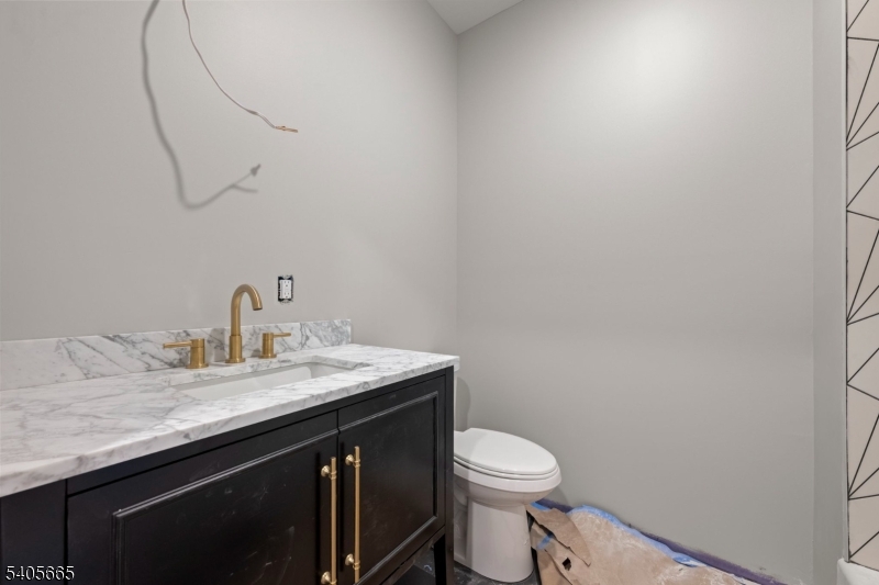 512 South 15th Street Newark, NJ 07103 - Photo 17 of 35 a bathroom with a granite countertop sink a toilet and a mirror