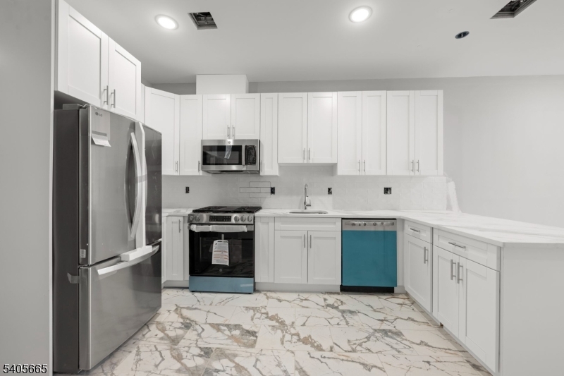 512 South 15th Street Newark, NJ 07103 - Photo 27 of 35 a kitchen with stainless steel appliances granite countertop a refrigerator sink and stove