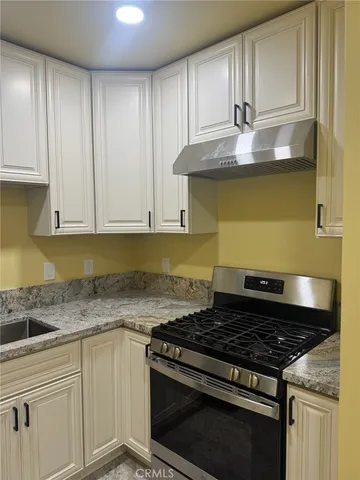 a stove top oven sitting inside of a kitchen