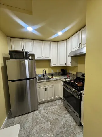 a kitchen with a refrigerator sink and cabinets