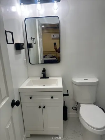 a bathroom with a toilet a sink and mirror