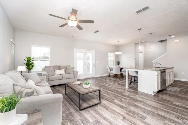 a living room with furniture and a wooden floor