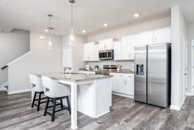 a kitchen with stainless steel appliances granite countertop a stove a sink and a microwave