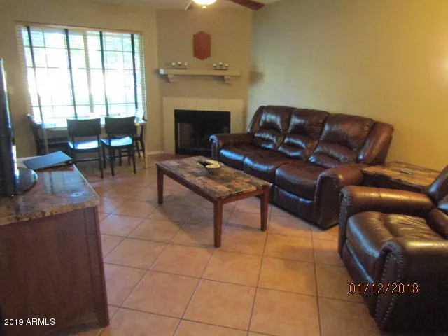 a living room with furniture a fireplace and a large window