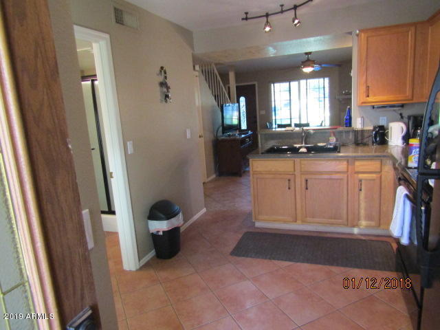 5808 East Brown Road, Unit 146 Mesa, AZ 85205 - Photo 4 of 10 a kitchen with stainless steel appliances granite countertop a refrigerator and a sink