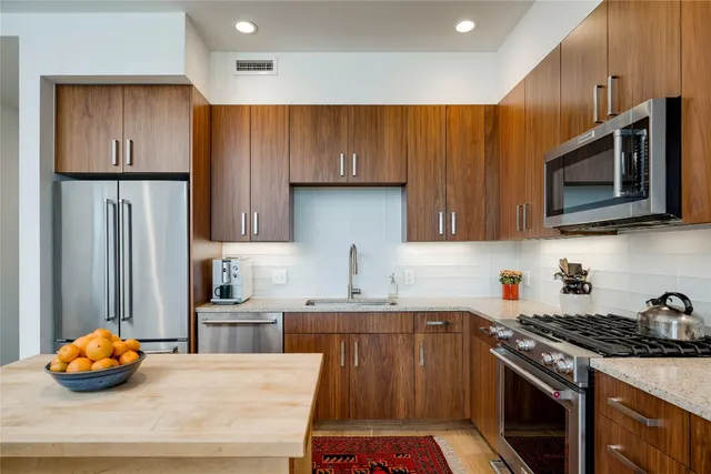 a kitchen with stainless steel appliances a stove a sink and a microwave