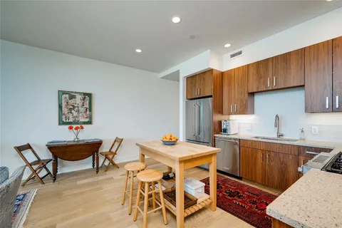 a kitchen with a dining table chairs and white appliances