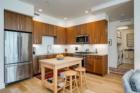 a kitchen with stainless steel appliances granite countertop a refrigerator stove microwave and sink