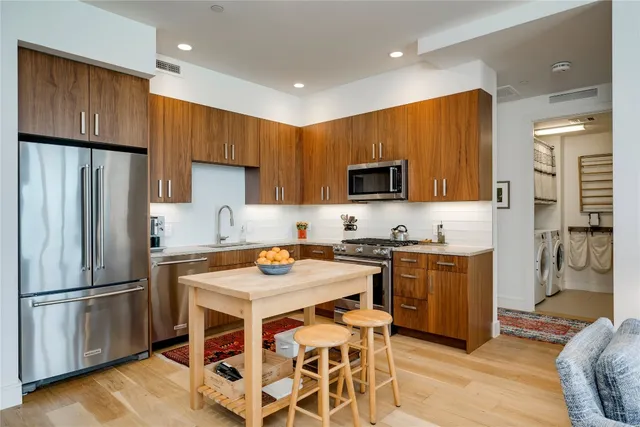 a kitchen with stainless steel appliances granite countertop a refrigerator stove microwave and sink