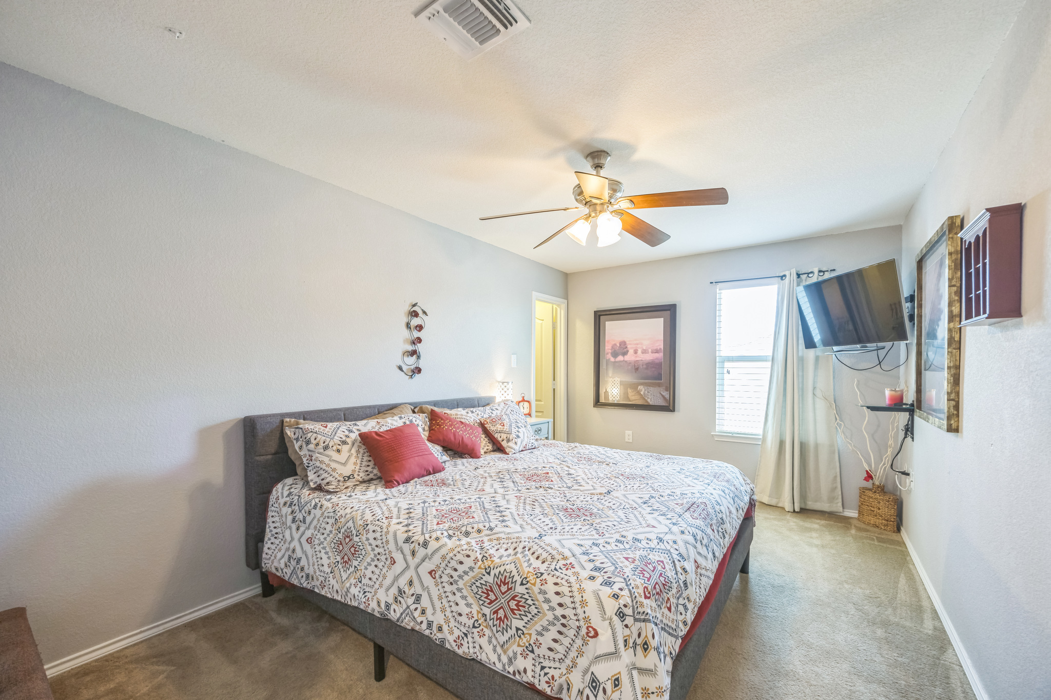 6401 Quinton Drive Austin, TX 78747 - Photo 22 of 29 a bedroom with a large bed and a chandelier