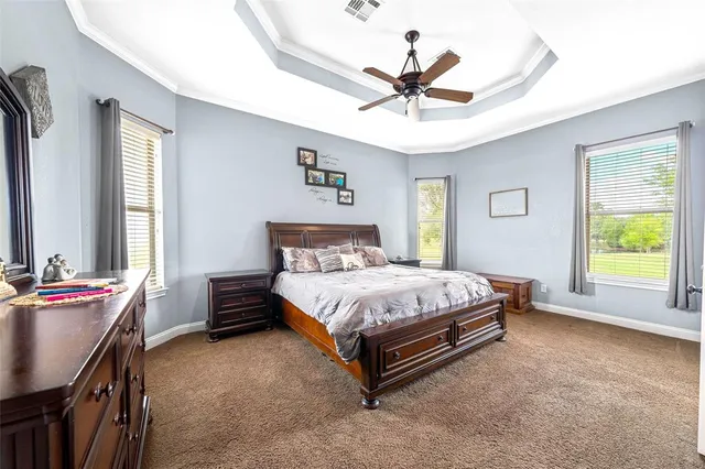 a spacious bedroom with a bed and a chandelier