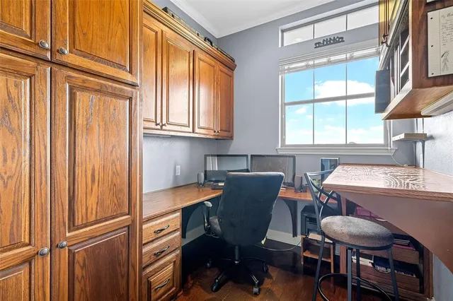 a view of a workspace with furniture and a window