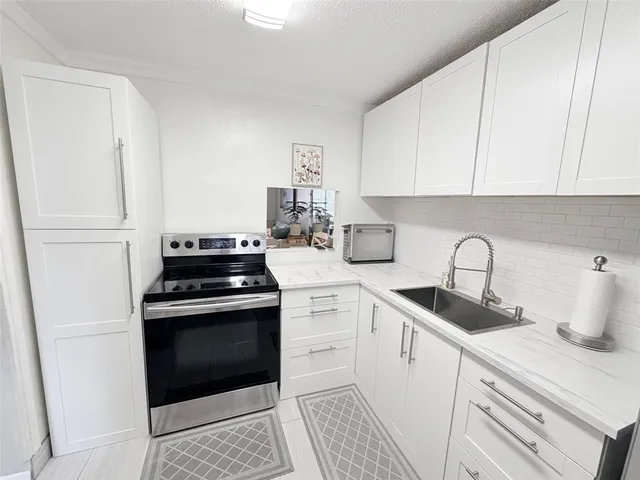 a kitchen with white cabinets and white appliances