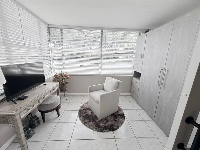 a living room with furniture a flat screen tv and a window