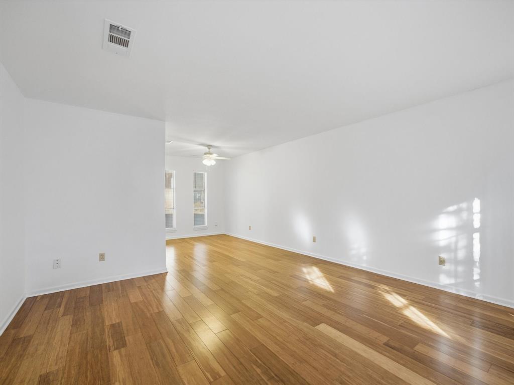4613 Ranch View Road Fort Worth, TX 76109 - Photo 11 of 24 an empty room with wooden floor and windows
