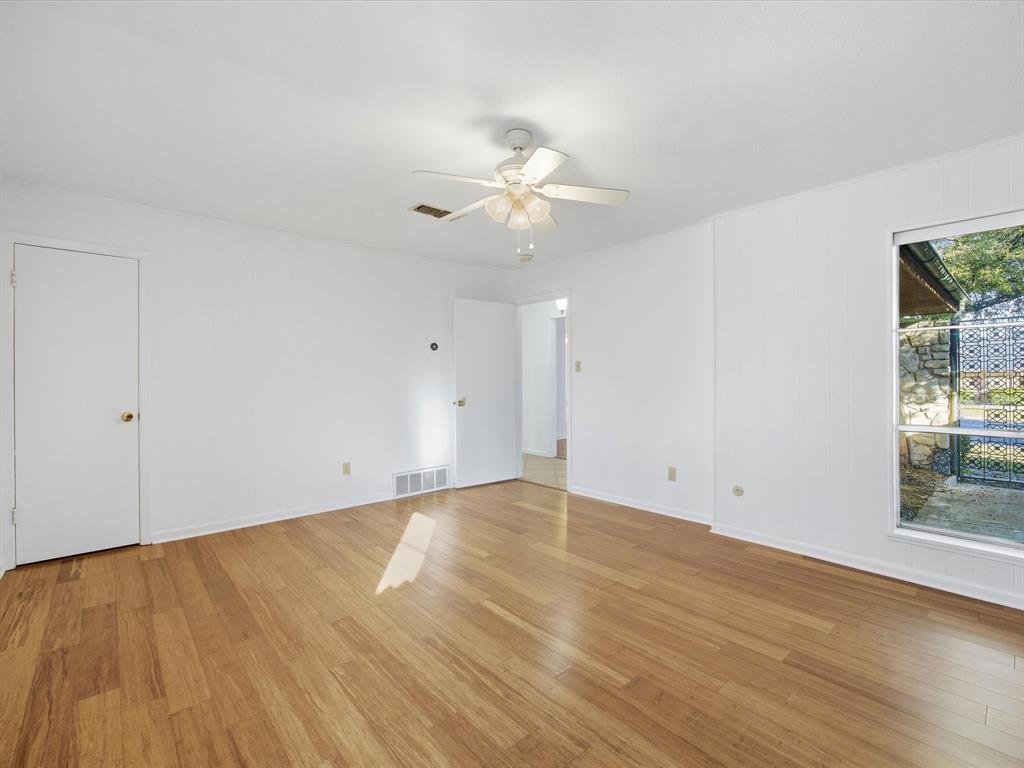 4613 Ranch View Road Fort Worth, TX 76109 - Photo 8 of 24 a view of an empty room with chandelier fan and wooden floor