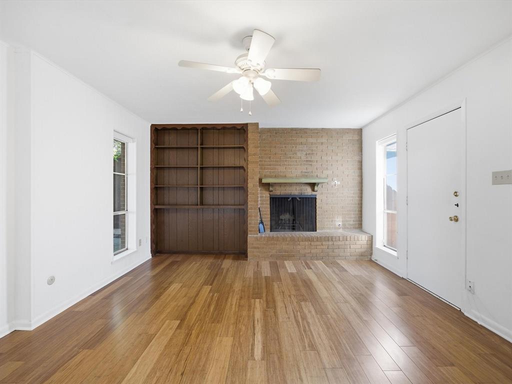 4613 Ranch View Road Fort Worth, TX 76109 - Photo 10 of 24 a view of an empty room with wooden floor fireplace and a window