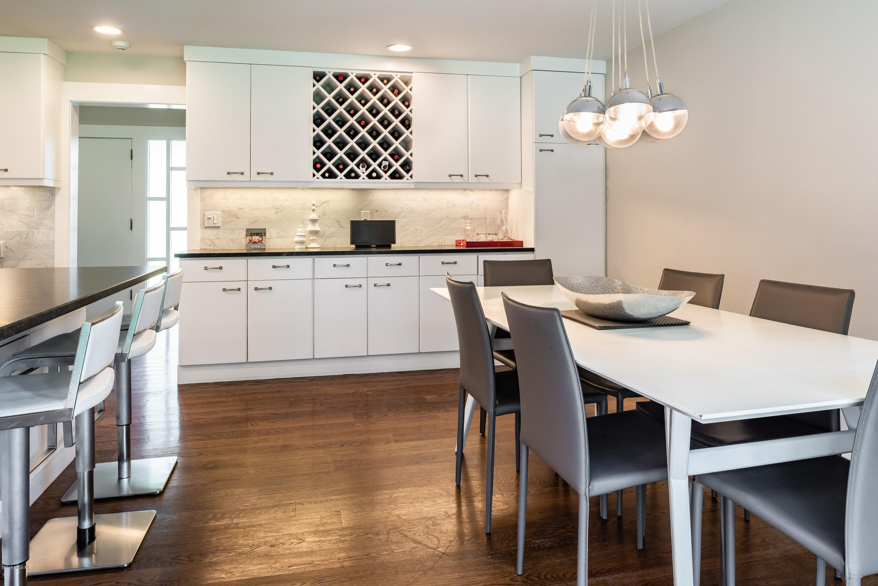 84 Burning Tree Road Greenwich, CT 06830 - Photo 12 of 28 a kitchen with granite countertop a table chairs a sink dishwasher a dining table and chairs with wooden floor