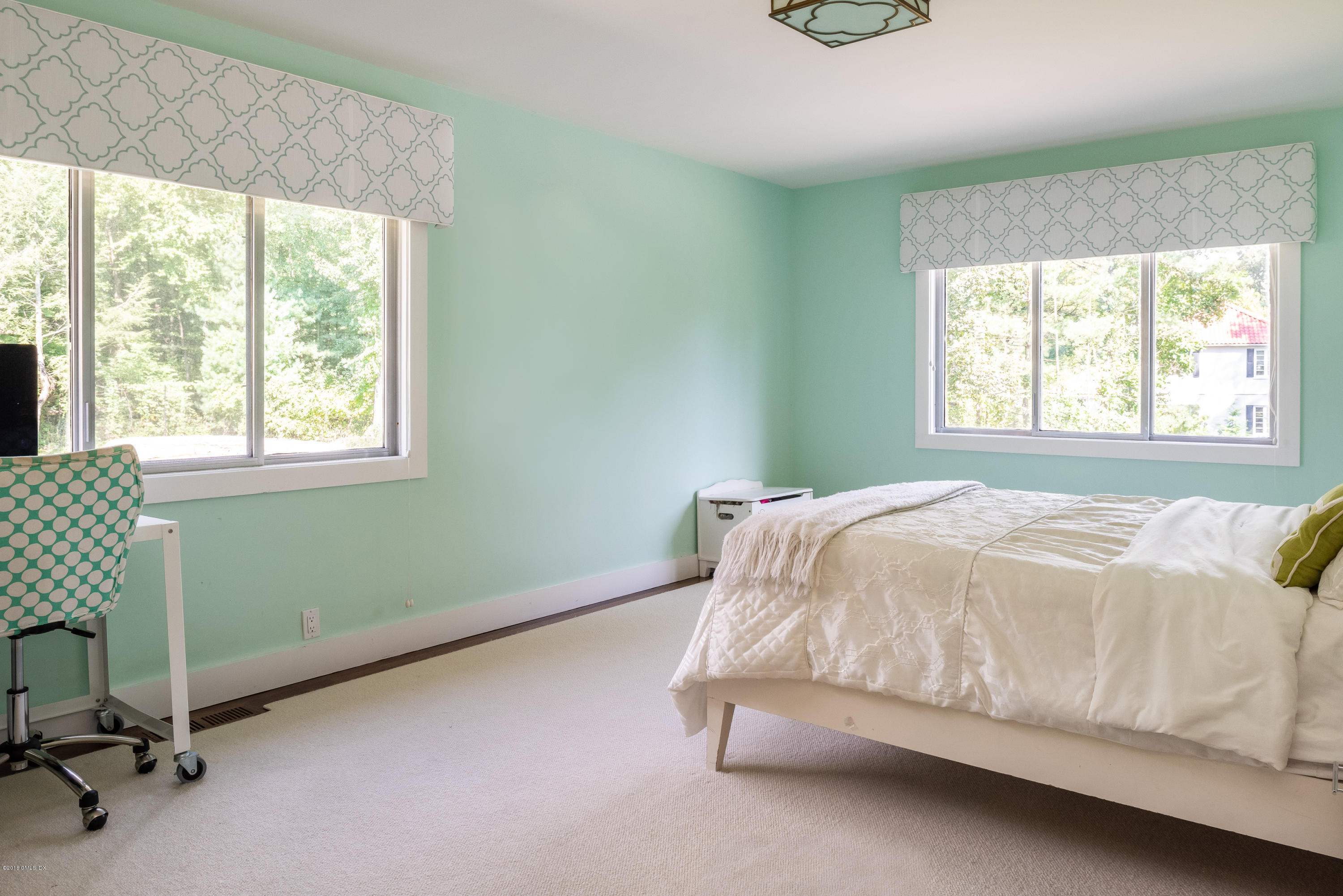 84 Burning Tree Road Greenwich, CT 06830 - Photo 19 of 28 a bed sitting in a bedroom next to a window