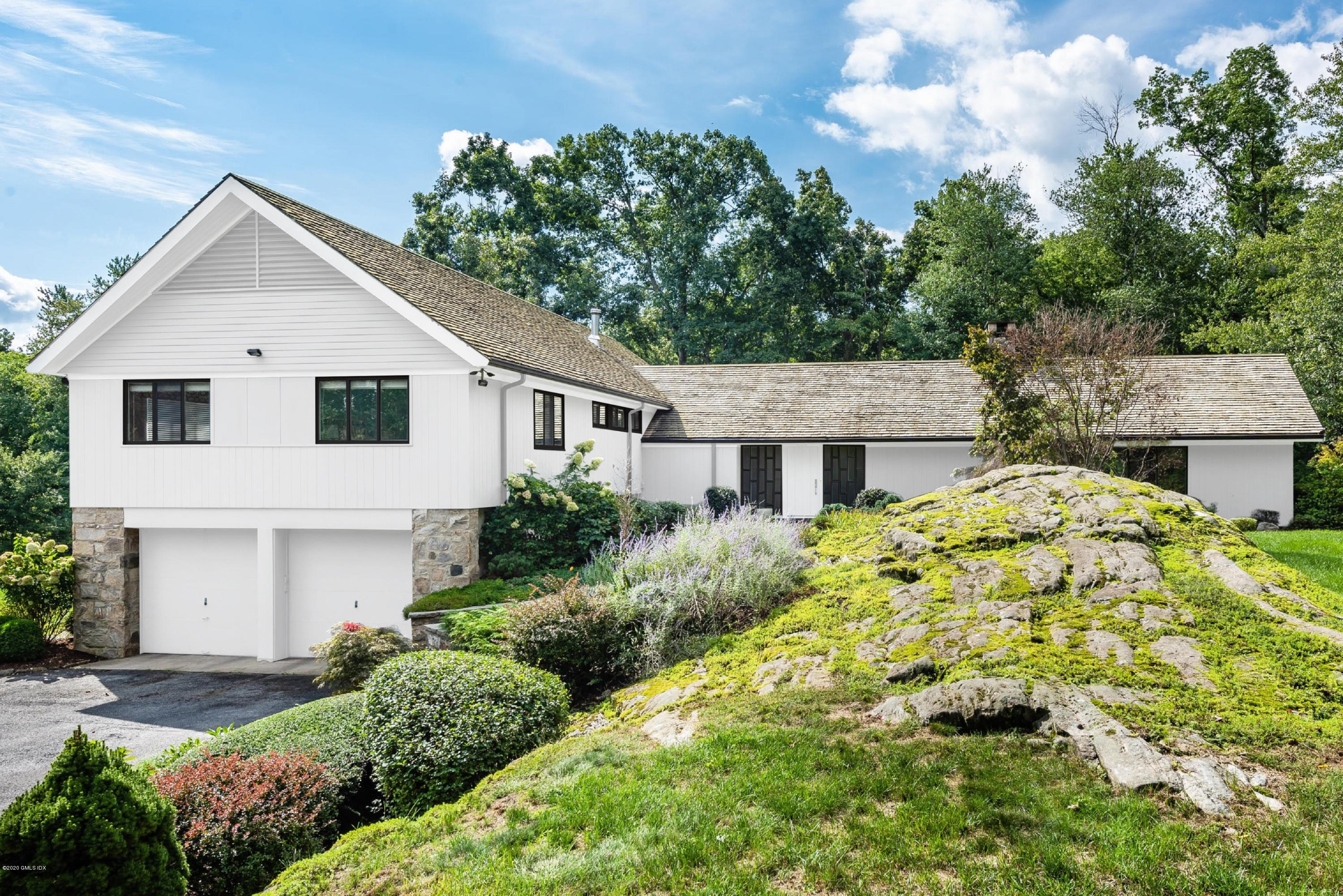 84 Burning Tree Road Greenwich, CT 06830 - Photo 2 of 28 a front view of a house with a garden