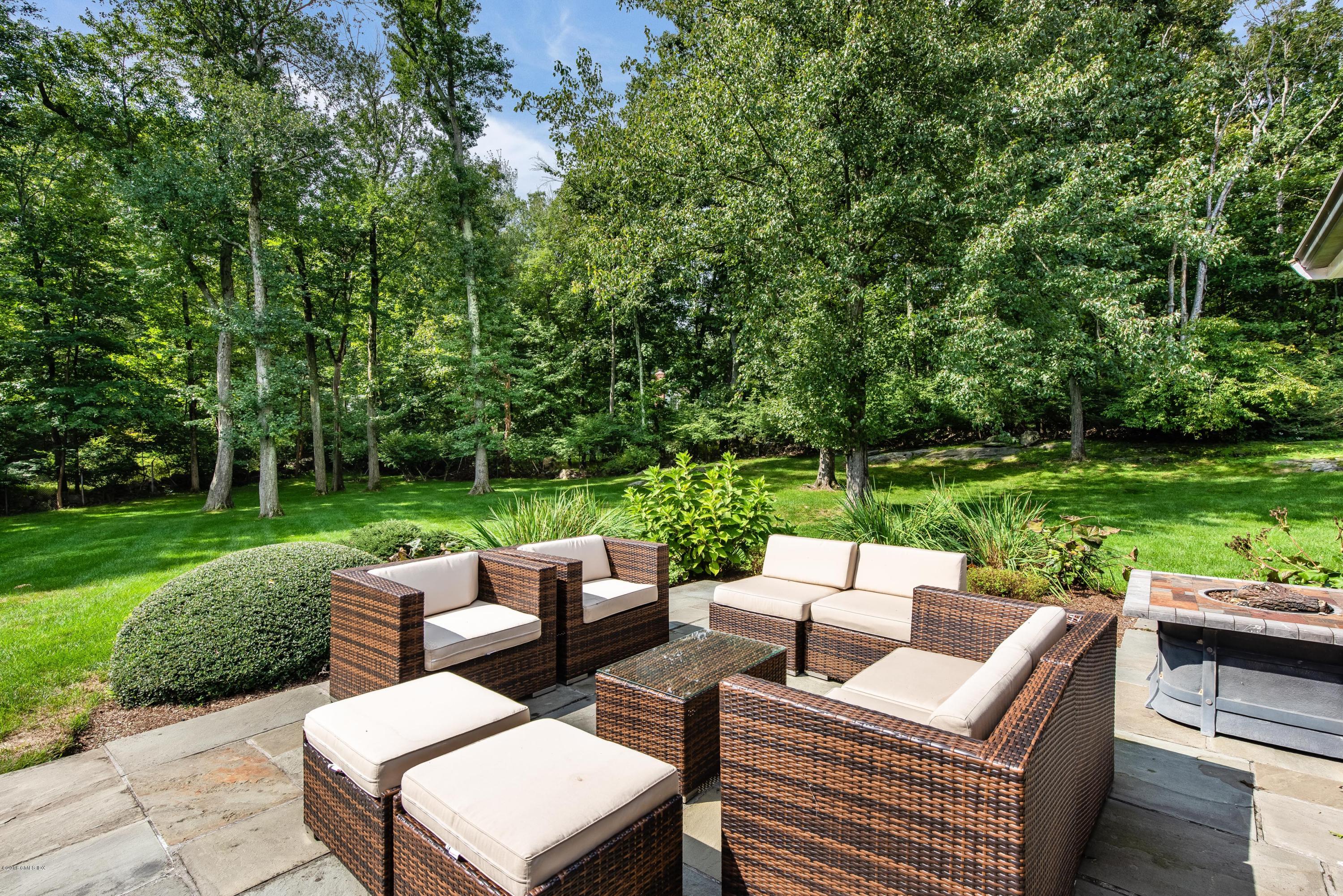 84 Burning Tree Road Greenwich, CT 06830 - Photo 26 of 28 a view of a patio with couches chairs and a yard