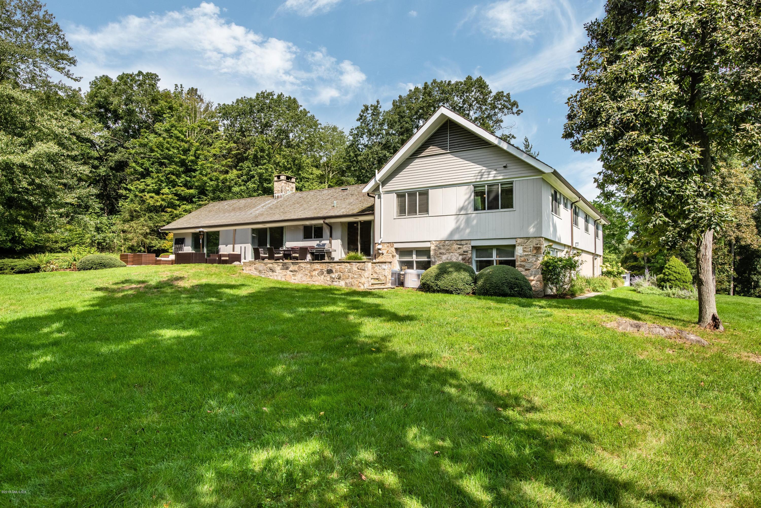 84 Burning Tree Road Greenwich, CT 06830 - Photo 27 of 28 a front view of a house with yard and green space