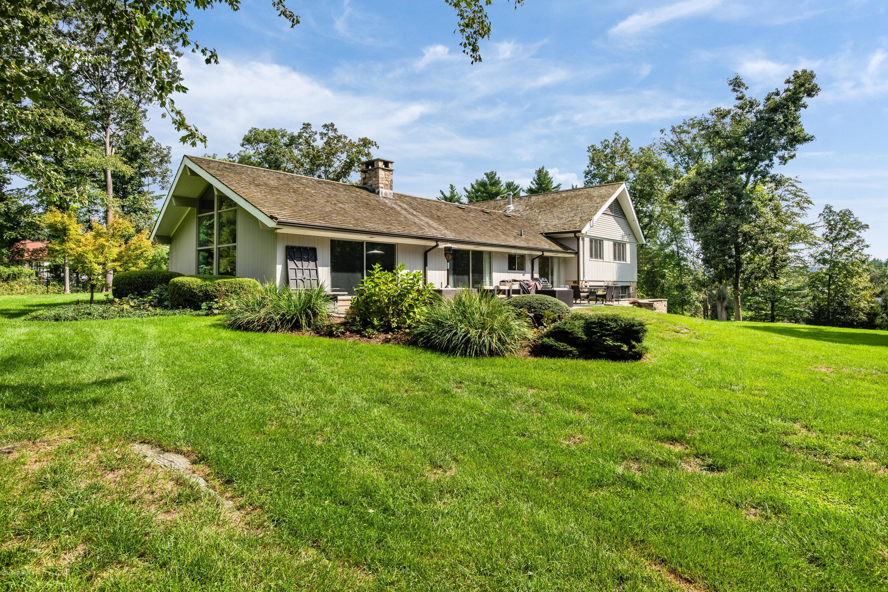 84 Burning Tree Road Greenwich, CT 06830 - Photo 28 of 28 a front view of a house with a yard