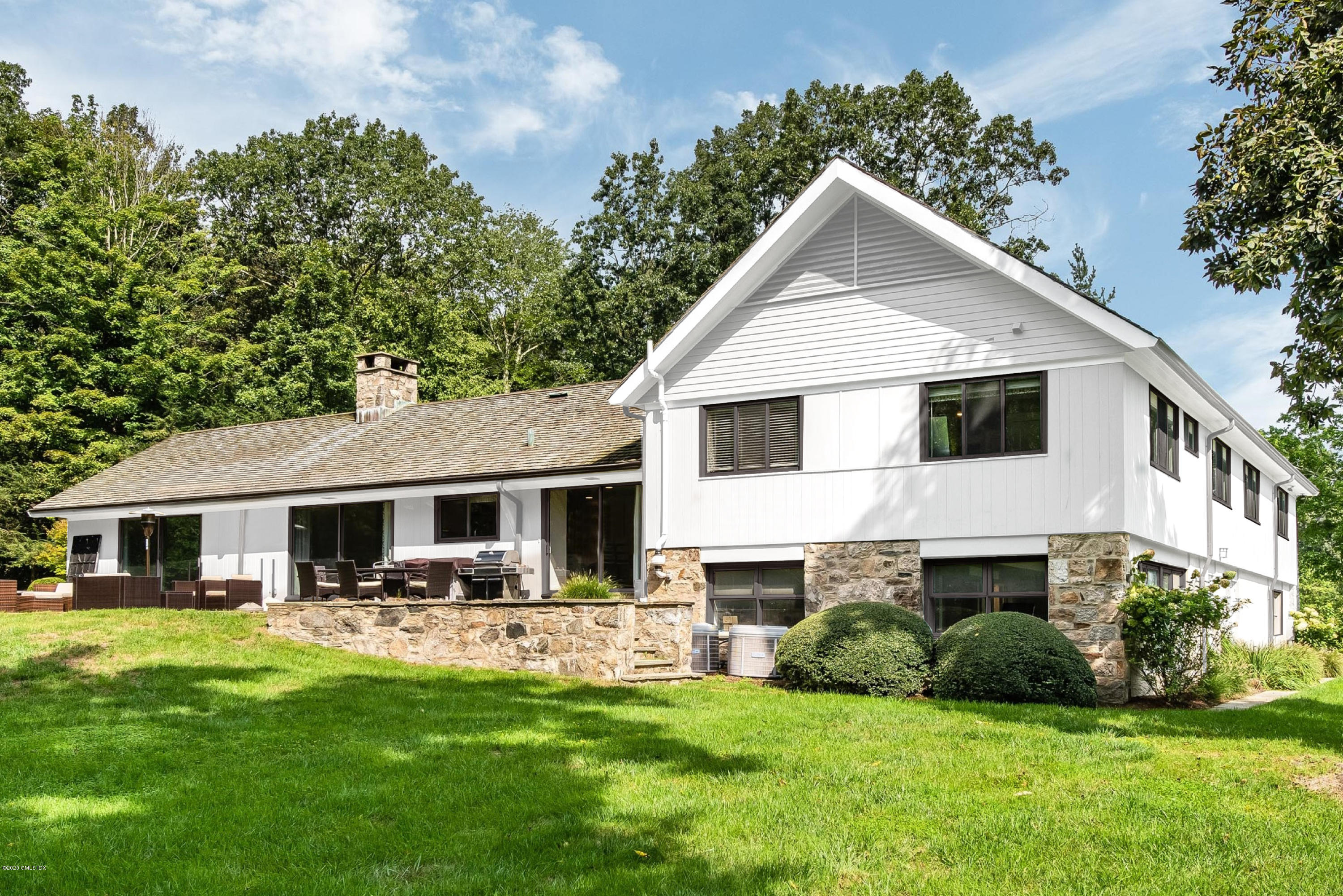84 Burning Tree Road Greenwich, CT 06830 - Photo 3 of 28 a front view of a house with a yard and green space