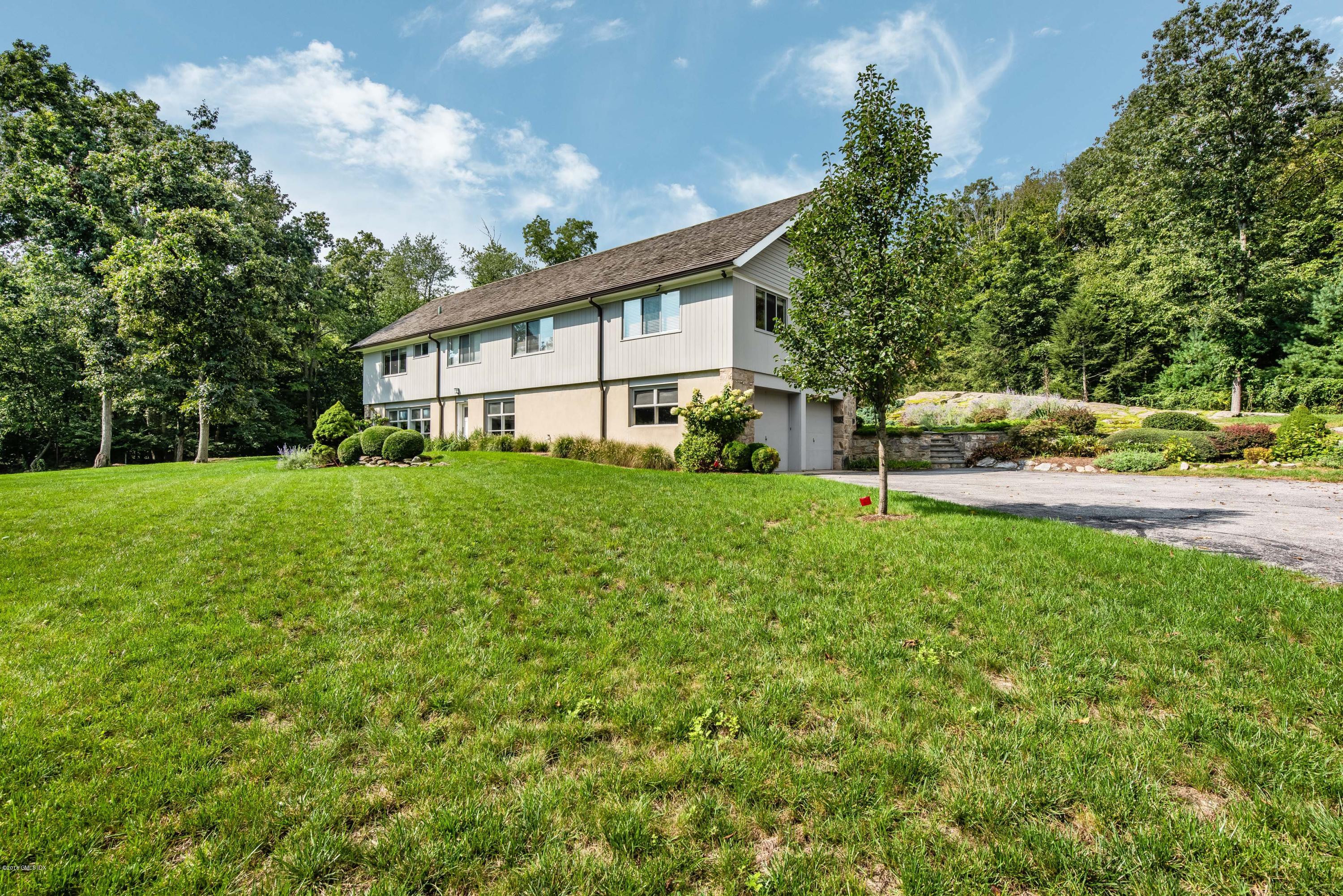 84 Burning Tree Road Greenwich, CT 06830 - Photo 5 of 28 a view of a house with a big yard and large trees