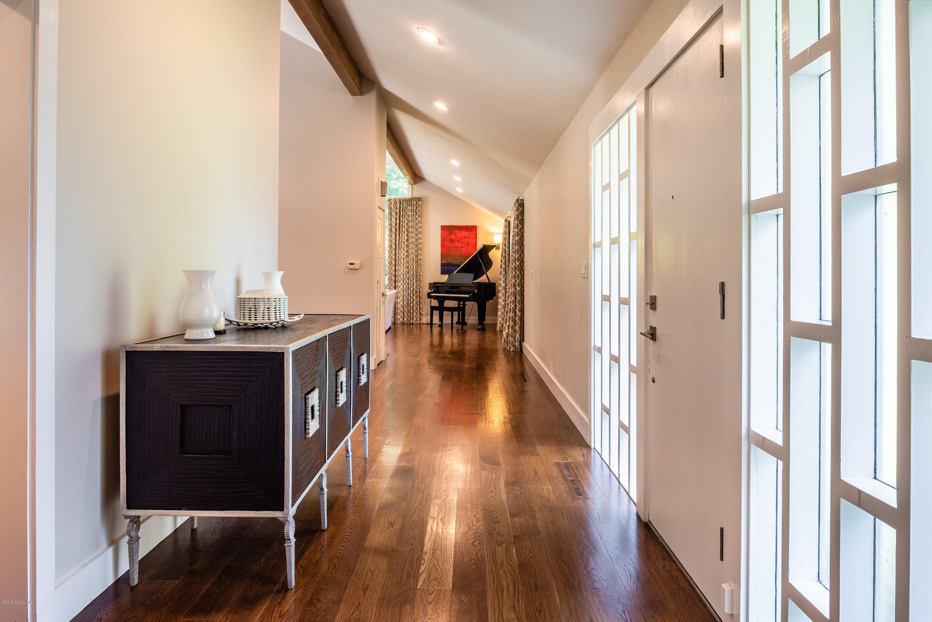 84 Burning Tree Road Greenwich, CT 06830 - Photo 7 of 28 a hallway with wooden floor closet and windows