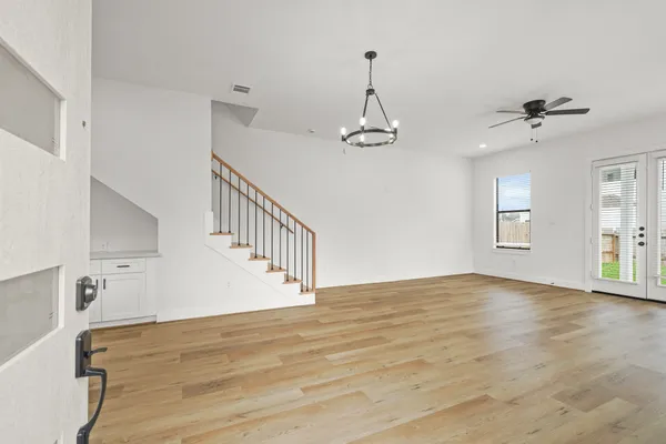 a view of an empty room with a window and wooden floor