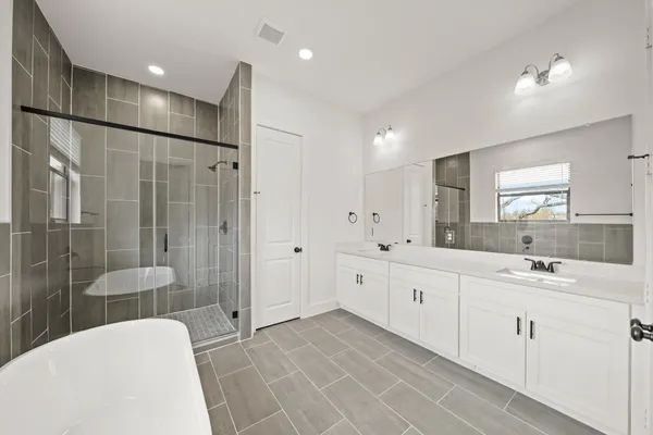 a large bathroom with a double vanity sink a large mirror and shower