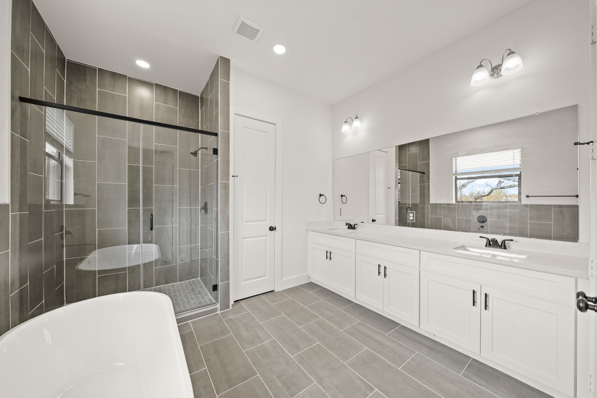 3419 Tuam Street Houston, TX 77004 - Photo 21 of 28 a large bathroom with a double vanity sink a large mirror and shower