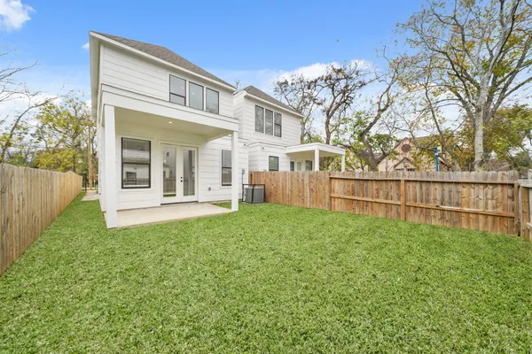 a view of a house with backyard and a tree