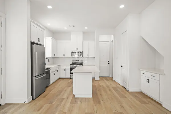 a kitchen with stainless steel appliances a refrigerator and a stove top oven
