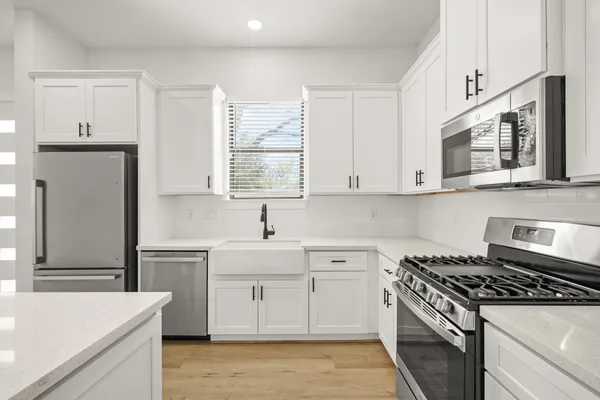 a kitchen with stainless steel appliances a sink stove and cabinets