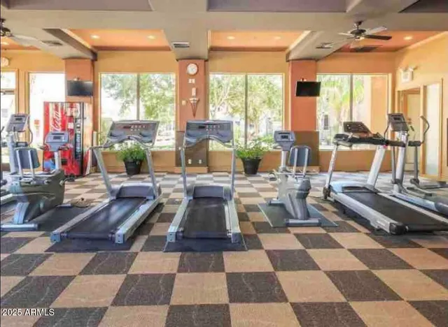 a living room with a black white checkered floor with a gaming machine and dining chairs