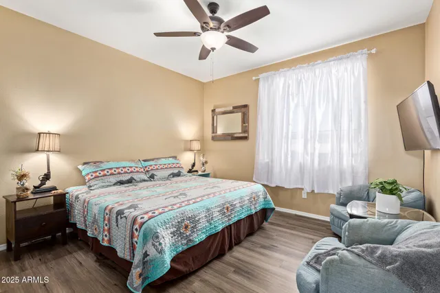 a bedroom with a bed couch and a ceiling fan