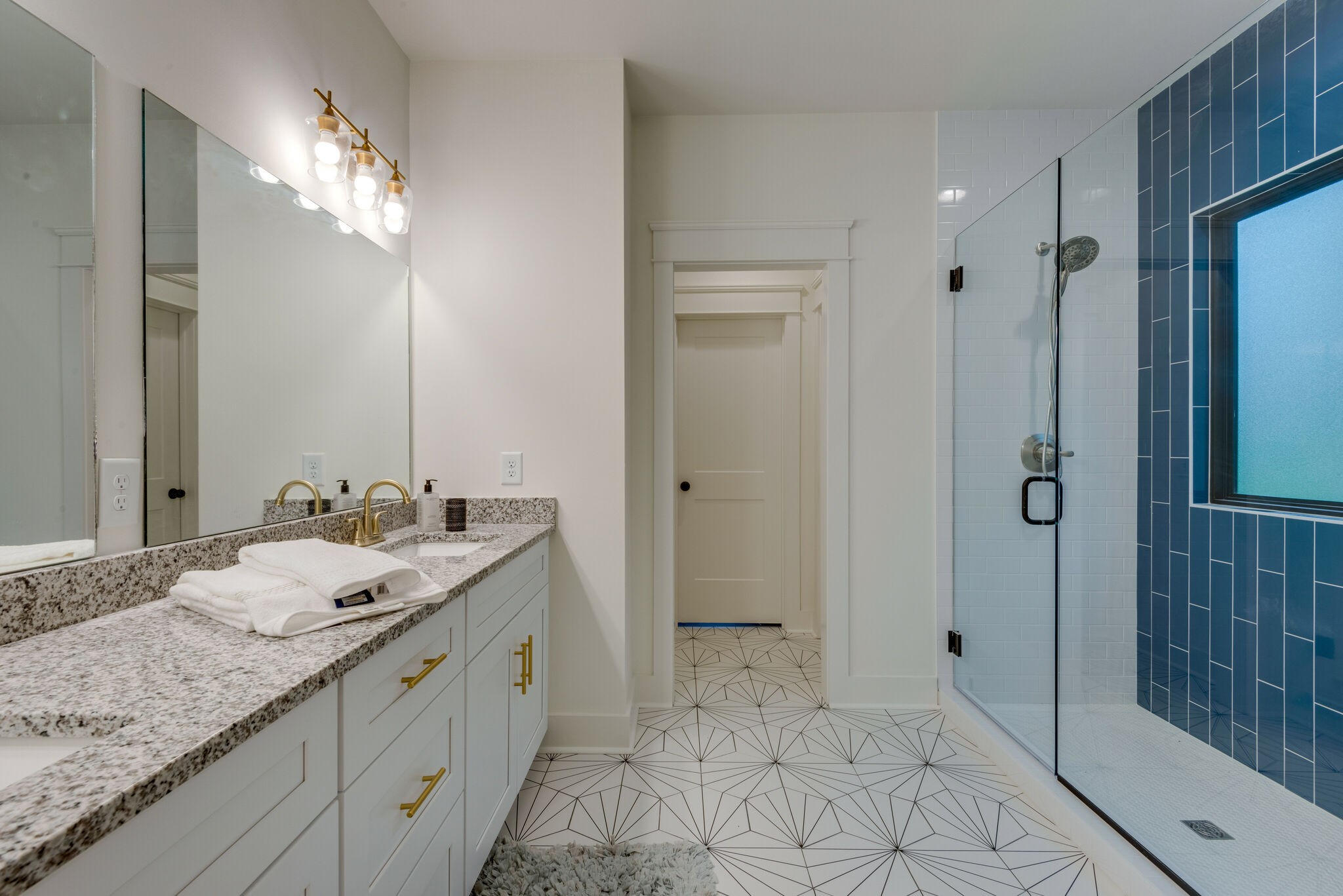 1106 Garton Road Burns, TN 37029 - Photo 24 of 46 a spacious bathroom with a granite countertop sink a mirror and shower