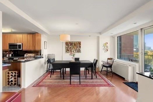 a living room with furniture a large window and kitchen view