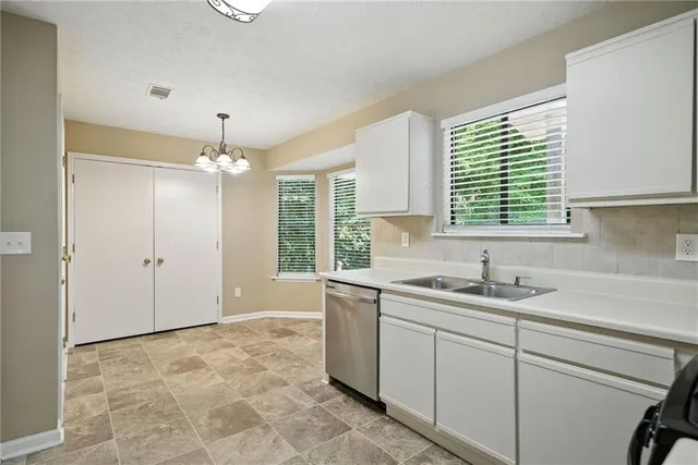 a view of a kitchen with a sink and chandelier