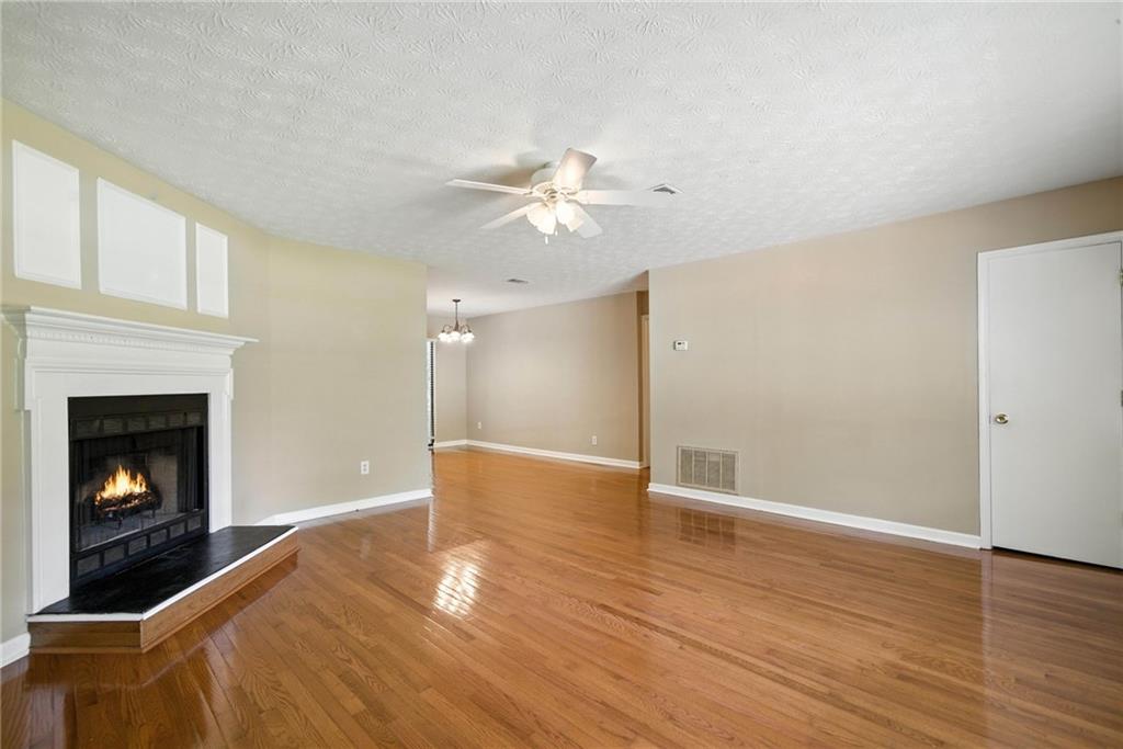 3045 Wildflower Lane Southwest Snellville, GA 30039 - Photo 7 of 35 a view of a livingroom with a fireplace a ceiling fan and wooden floor